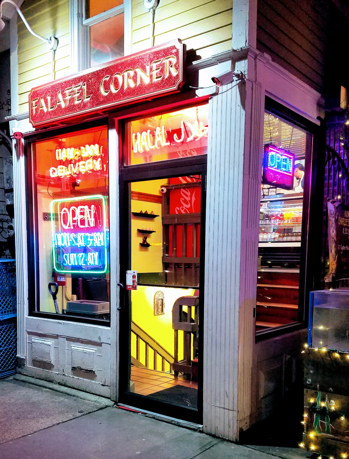 a small corner falafel restaurant colorfully lit