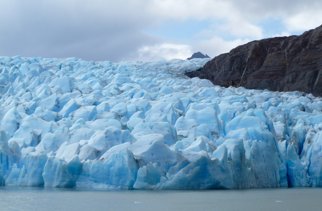 hundreds of pointed glaciers close together with sky and mountain in the background