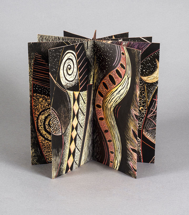 artist book open in a circle with swirling warm designs
